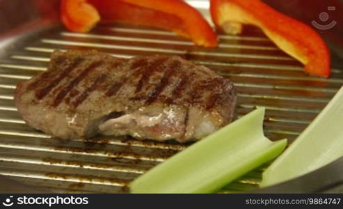 Beef steak grilled with vegetables in a frying pan