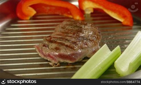 Beef steak grilled with vegetables in a frying pan