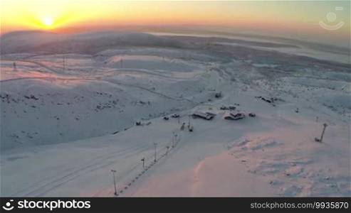 Bird's eye view of the sun rising over the ski resort in the Khibiny mountains
