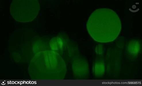 Black abstract background with green blurred particles