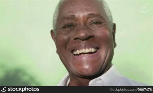 Black people smiling, portrait of an old African American man looking at the camera and laughing. Sequence