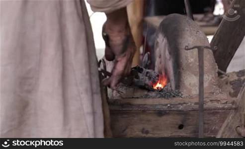 Blacksmith at work. Heating of the metal in the furnace.