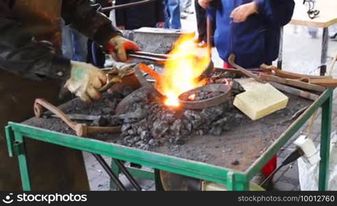 Blacksmith takes from fire two hot metal rings