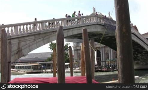 Blick in die Kanäle in Venedig mit Bootsverkehr. Im Vordergrund eine Brücke.