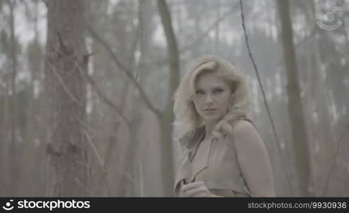 Blonde woman in the forest looking like trying to escape from the scene