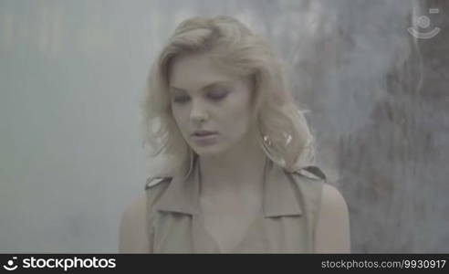 Blonde woman in the forest with the smoke behind