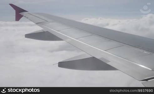 Blue sky with clouds. An aerial view from an airplane. Clouds and airplane wing seen from the window of an aircraft.