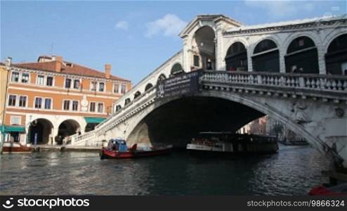 Boats and water buses pass under the Rialto Bridge in Venice.