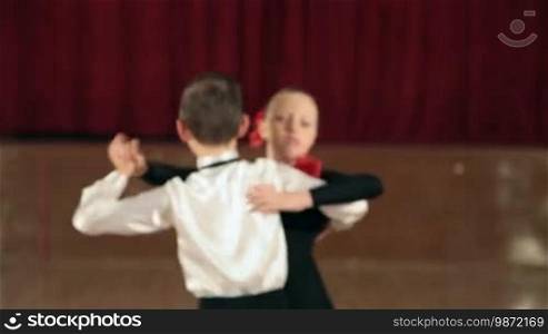 Boy and girl, 9 years old, dancing the Tango in the ballroom.