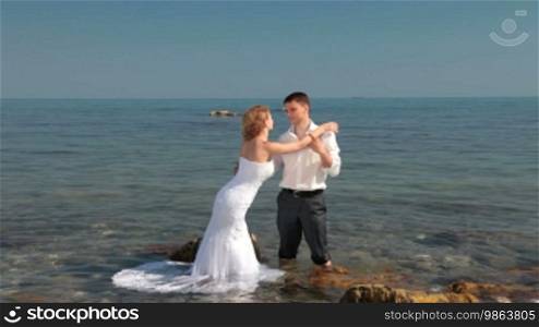 Bride and groom hugging at beach