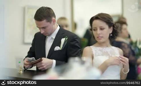 Bride and groom in register office paying for optional services.