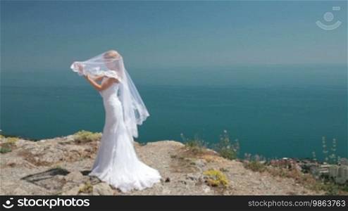 Bride posing in the mountains against the blue sky