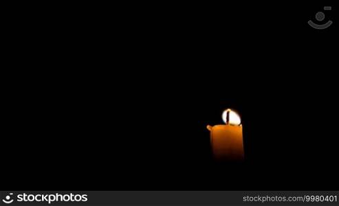Burning candle isolated on black background