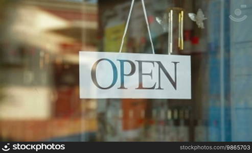 Business owner turns sign from open to closed in front of her store