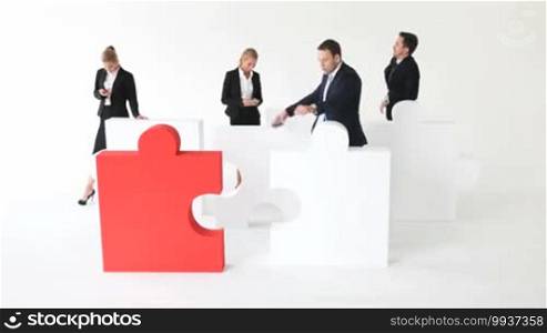 Business people and puzzle on white