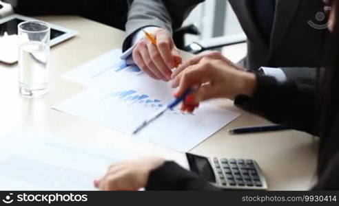 Business people discuss financial reports - close-up view