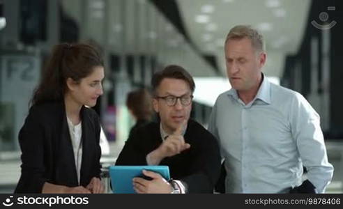 Business people looking at a digital tablet in a cafe during a meeting