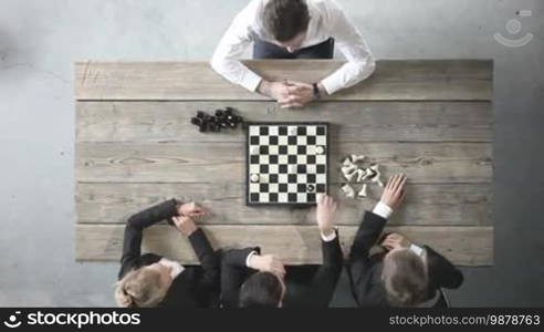 Business people playing chess, team of workers losing, leader is winning, people shaking hands