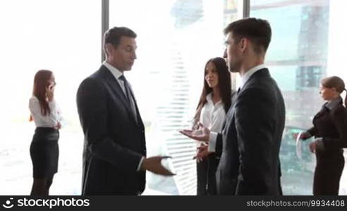 Business people shaking hands at a meeting in the office, with skyscrapers in the background