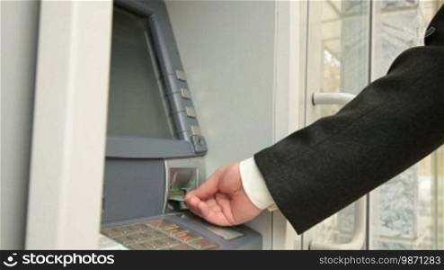 Businessman Checking Account Balance at an ATM Machine