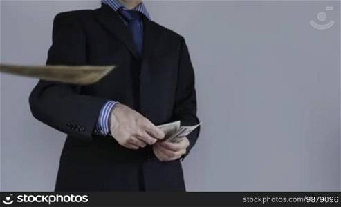 Businessman throws money into camera, Dollars
