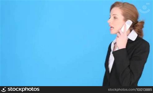 Businesswoman talking into mobile phone, upper body isolated on blue with copyspace.
