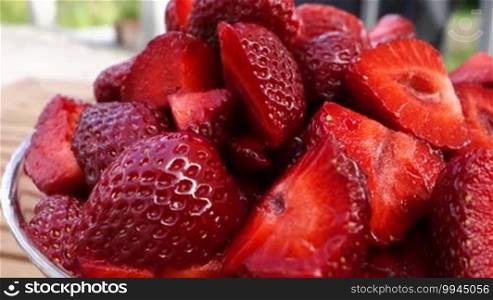 Camera movement along a bowl of fresh strawberries