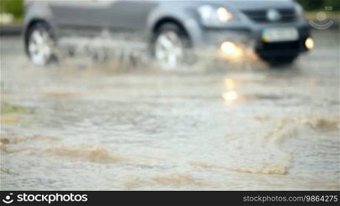 Car crossing a flooded road after strong rain