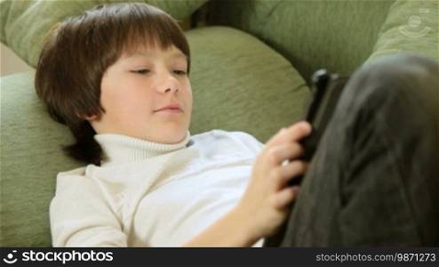 Child Using a Touch Screen Tablet PC At Home