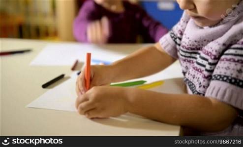 Children having fun at school, two happy young girls drawing in kindergarten. Sequence