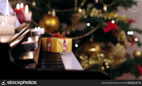 Christmas gift on piano. Christmas tree and decoration with gift on piano.