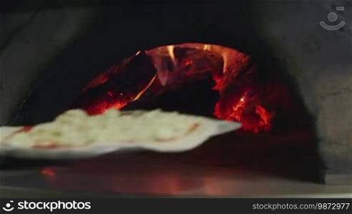 Close-up of pizza cooking in wood oven with fire and flames, restaurant kitchen in Italy. Traditional food, bakery, Mediterranean diet. 11 of 14