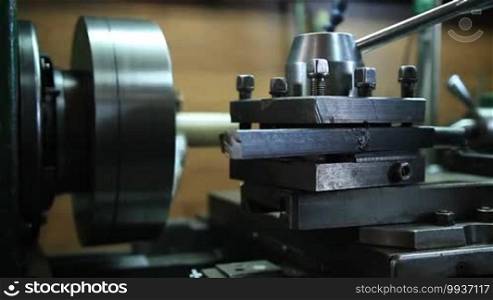 Close up of tools and equipment of old-fashioned manual lathe machine. Worker operating vintage turning lathe machine in the workshop.