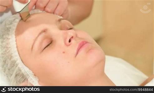 Close-up shot of a young woman undergoing an ultrasonic facial cleansing session