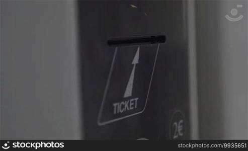 Close-up shot of child hand getting ticket from ticket-machine