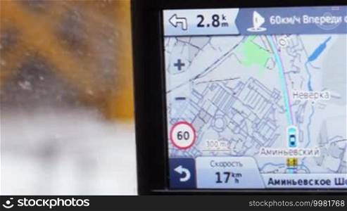 Close-up shot of GPS monitor in moving car. It displaying route, speed of driving and distance to nearest turning