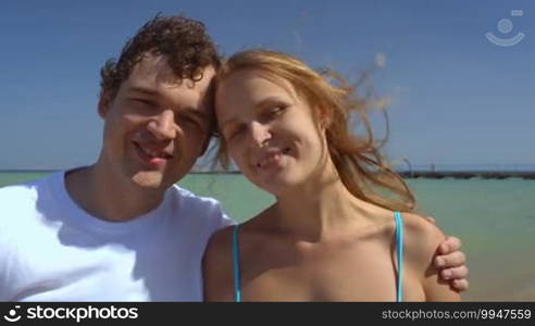 Close-up shot of loving couple being happy together. Sea and sky background