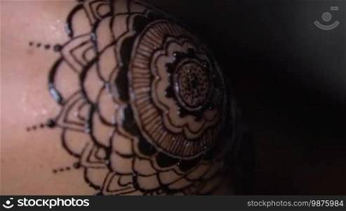 Closeup freshly done henna tattoo on woman's shoulder - video in slow motion