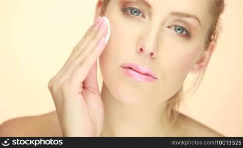 Closeup of blonde woman cleaning her face