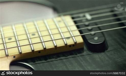 Closeup of electric guitar fretboard and pickups. Dolly shot