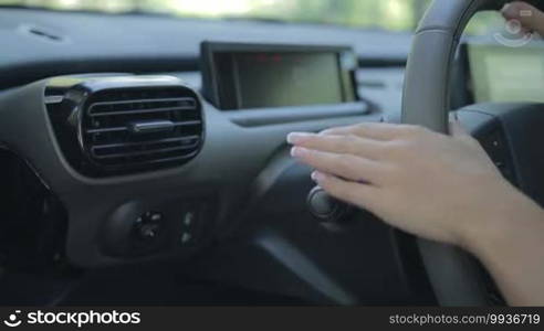 Closeup of woman driving car and using turn signal switch