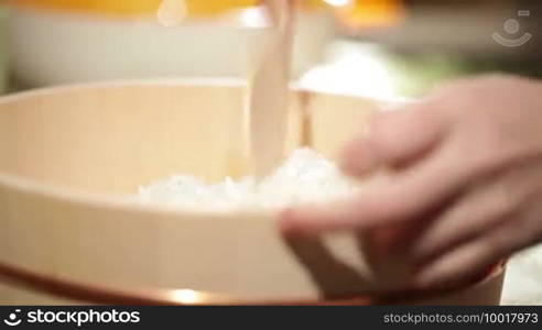 Cooking sushi. Mixing rice in a wooden plate. Beautiful macro with shallow depth of field.
