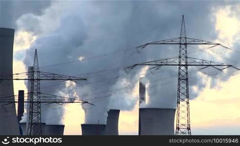 Cooling towers of a power plant release smoke and steam into the environment