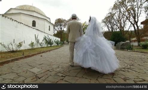 Crimean Tatar newlyweds walking through the park Bakhchisarai Palace (Hansaray, Khan's Palace) Bakhchisaray, Crimea, Ukraine. Lockdown, Wide Shot, Canon 5D Mark II