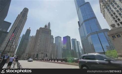 Crowds crossing the bridge at Michigan Ave. Chicago skyline rises in the background. Video process accelerated showing a landmark in Illinois. Trump Tower is one of the highest buildings in the city.