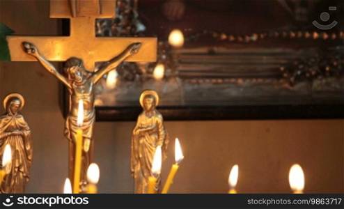 Crucifix and burning candles in the church