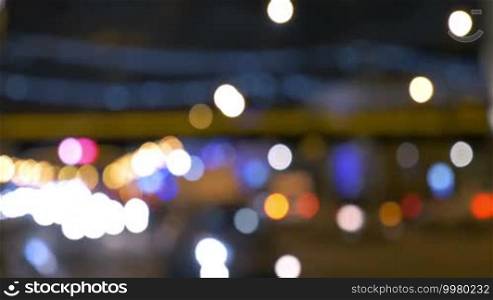 Defocus of road traffic at night. Blurred lights of city and car headlamps