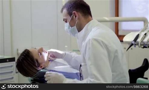 Dental care and hygiene, portrait of adult Caucasian dentist at work and smiling at camera with customer sitting on exam chair. Sequence