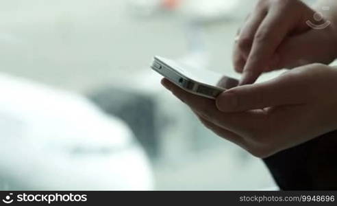 Dolly close-up shot of woman's hands typing text message on smartphone