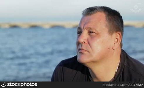 Dolly shot of a mature man enjoying seascape with a thoughtful look